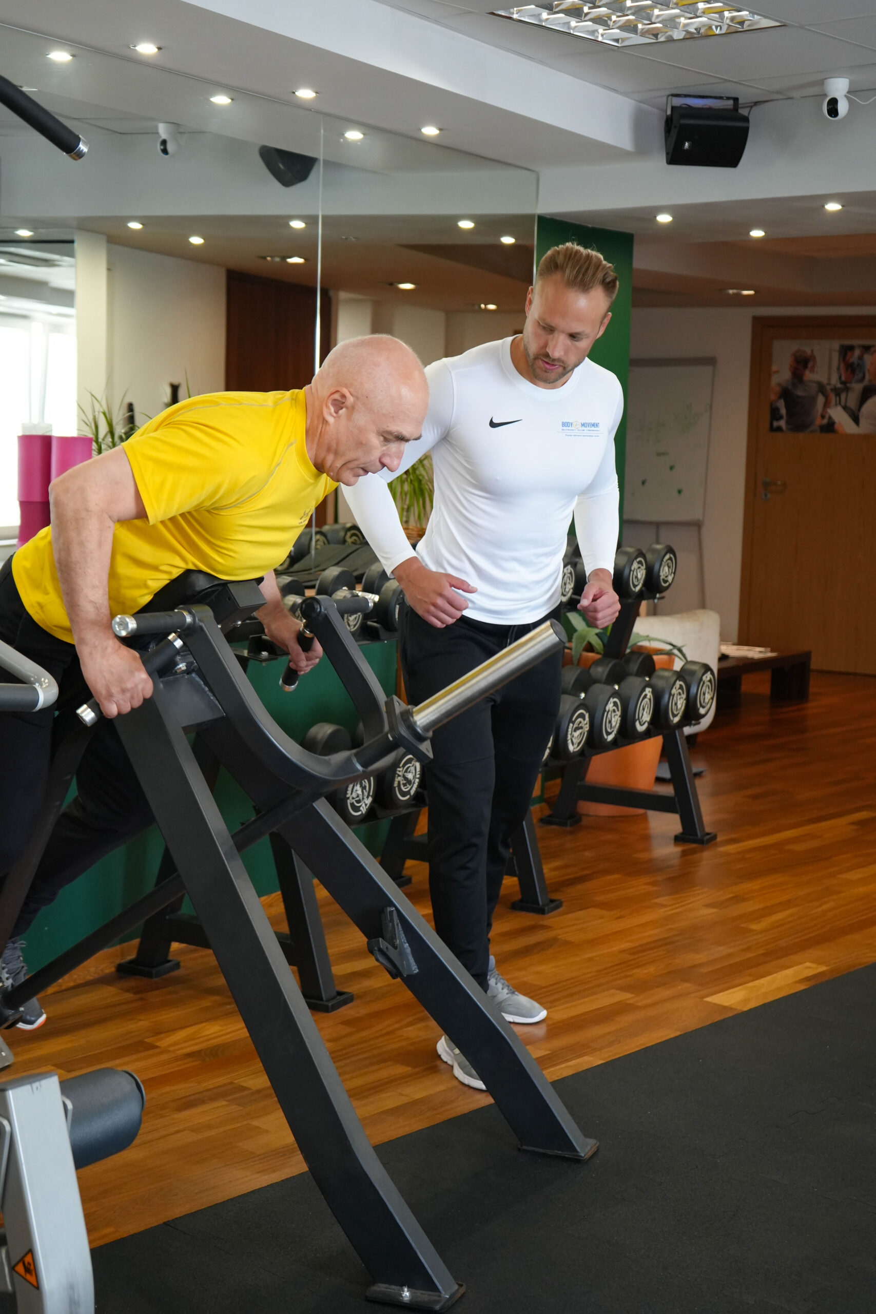 Trener personalny Body Movement prowadzi ćwiczenia siłowe z podopiecznym podczas treningu indywidualnego w Warszawie.